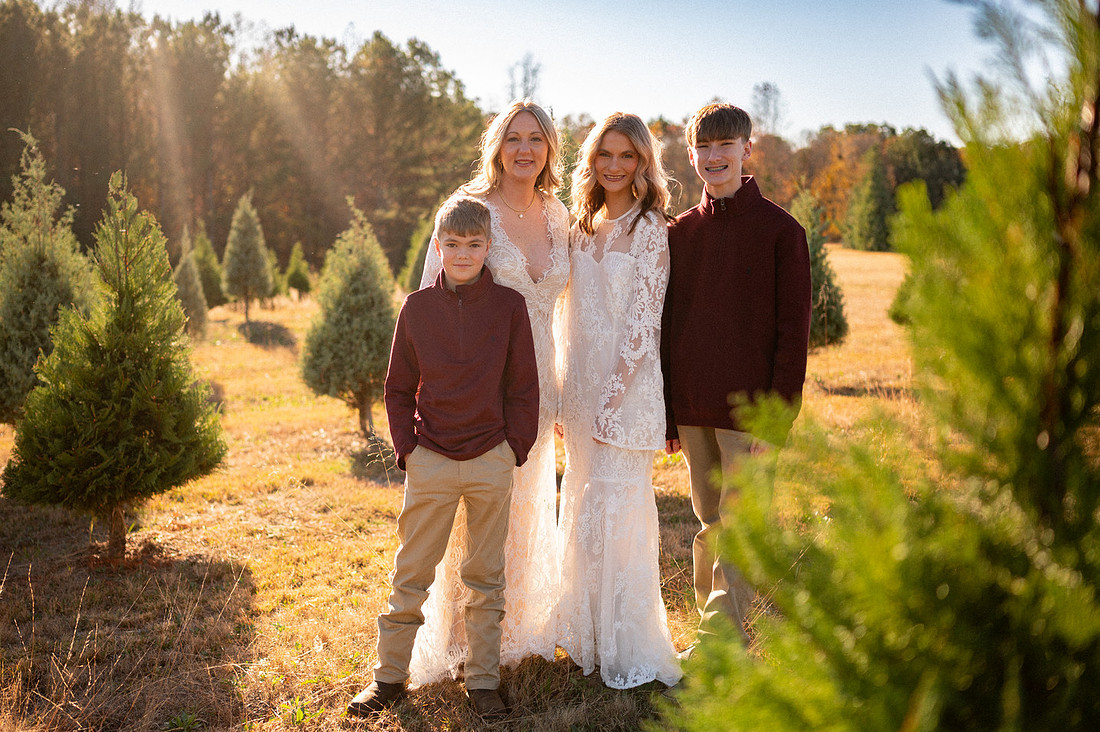 Family portrait among rows of evergreen trees