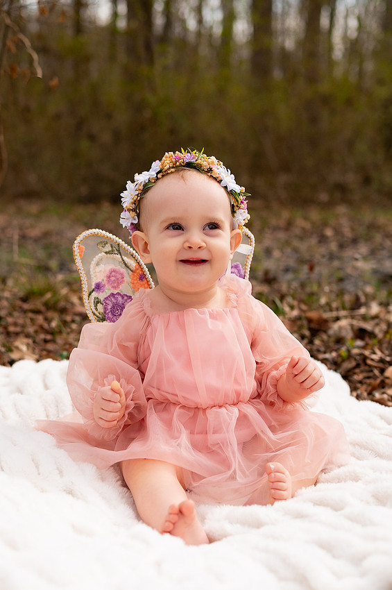 Smiling baby in a pink dress and flower crown